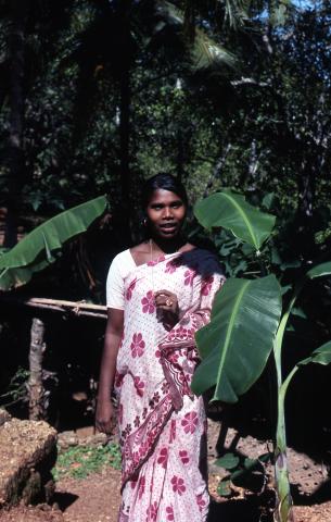 Photo of a woman standing beside banana tree