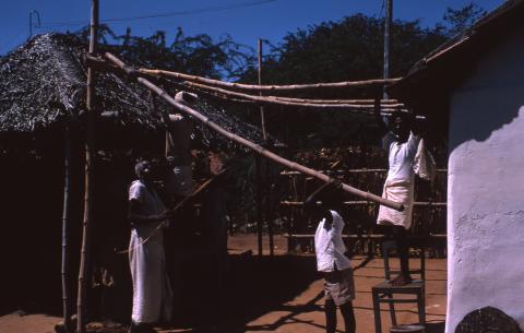 ஆண்கள் மூங்கில் கம்புகளால் கூரை செய்கின்றனர்