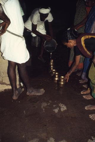 A man fills water in small pots