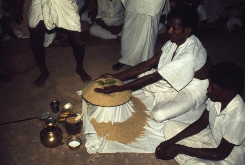 A man is perfoming a ritual with rice