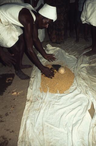 A man is spreading Paddy on a piece of cloth